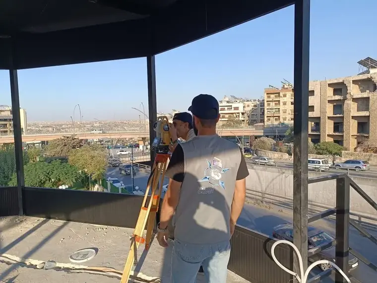 فريق المساحة على السطح مع إطلالة حلب